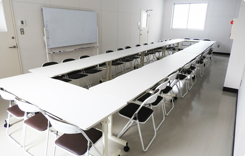 控室の様子。会議室のような長テーブルと椅子、ホワイトボード。