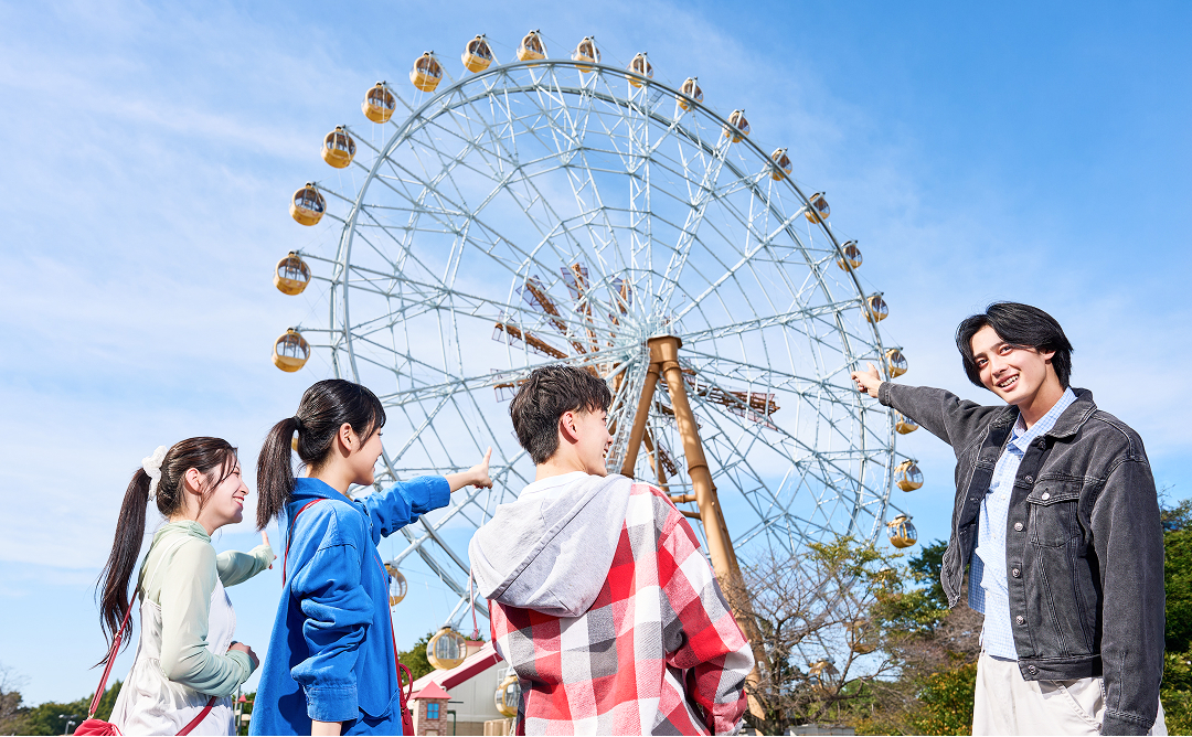 エマさんのチーズ風車を見上げる友達同士の様子