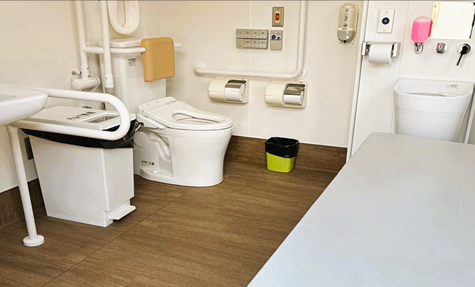 多機能トイレ内部の様子。広いエリア。手すりやゴミ箱、チャイルドグッズなど