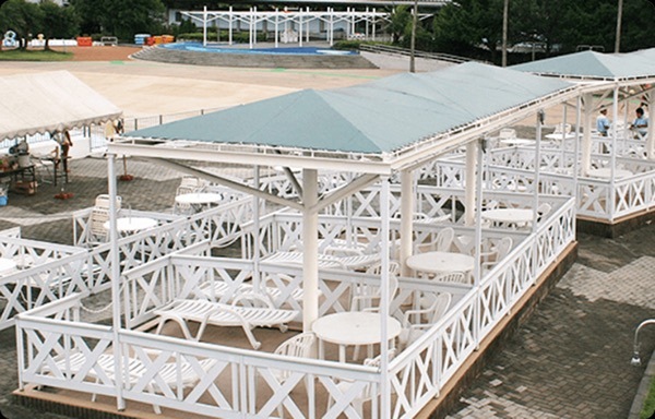 ロイヤルシート　区画が区切ってあるパラソル備え付けのボックス。白い丸テーブルとデッキチェア、パラソルがある写真